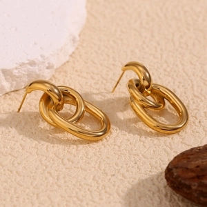 Gros plan de boucles d'oreilles ovales entrelacées en acier inoxydable doré 18K sur pierre