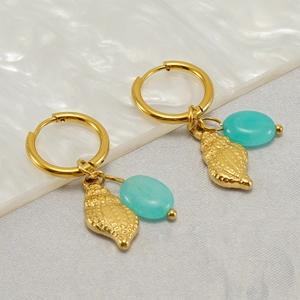 Retro turquoise drop hoop earrings with gold finish on white marble texture base