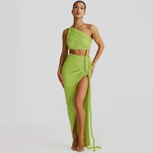 Detail of green one-shoulder crop top and high slit skirt with side drawstring ties