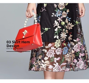Detail of high-waist mesh dress featuring heavy colorful floral embroidery and hem design