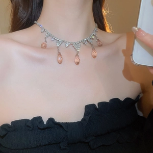 Close-up of zircon tassel necklace with pink teardrop gemstones on model's neck