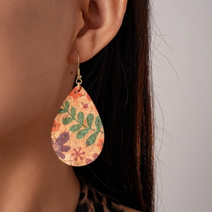 Gros plan de boucles d'oreilles en liège goutte avec imprimé floral coloré