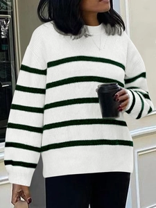 Street style view of women's white and dark green striped knit sweater with crew neck