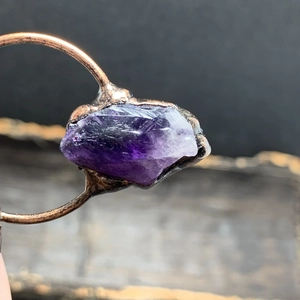Primer plano de cristal de amatista natural en bruto engastado en anillo de cobre retro