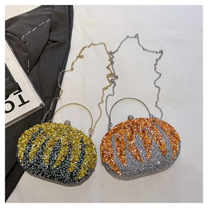 Detail of sequined pumpkin evening bag with metal ring handle and crossbody chain