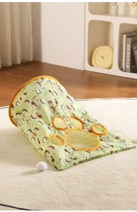 Close-up of foldable cat tunnel featuring five paw-shaped mesh windows and a plush ball toy