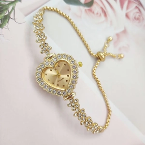 Close-up of heart-shaped gold quartz watch with rhinestone bracelet and adjustable clasp