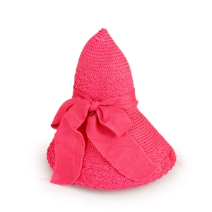 Detail of peach pink woven sun hat featuring a large ribbon bow and spiral texture