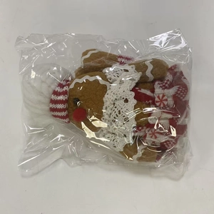 Detail shot of plush gingerbread man ornament in clear plastic protective packaging