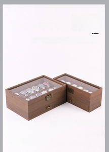 Detail view of walnut wood watch box with transparent glass top and metal hardware