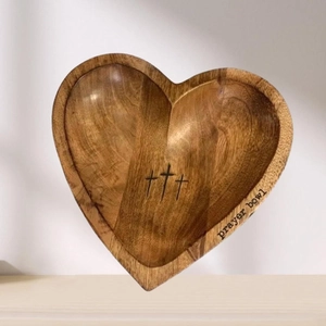 Handcrafted heart-shaped wooden prayer bowl with three engraved crosses on a rustic surface