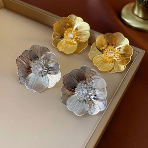 Floral stud earrings with hollow gold and silver petals and crystal centers