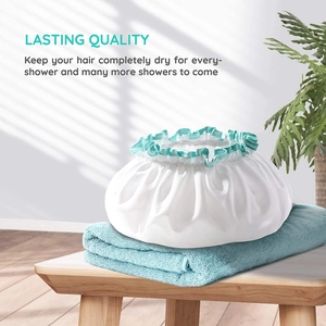 Detail of waterproof double-layer satin shower cap with elastic band on wood surface