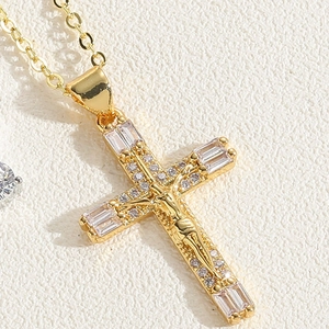 Detailed close-up of hollow gold cross pendant with Jesus relief and zircon accents
