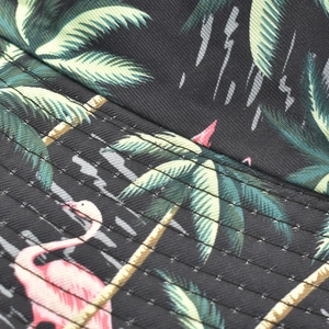 Detailed view of flamingo and palm tree print on black bucket hat with fine stitching