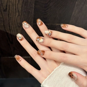 Handmade gradient amber press-on nails with silver star patterns and sparkling rhinestones