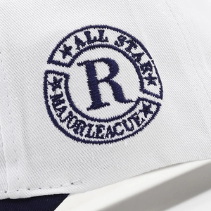 Detailed close-up of navy blue 3D embroidery on a white breathable twill baseball cap