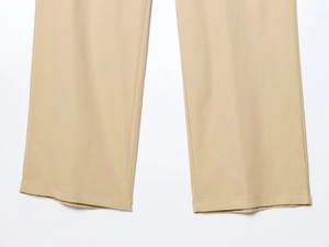 Close-up of beige straight-leg trousers showing high-quality stitching and fabric texture