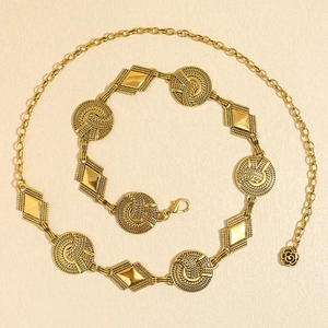 Detail of vintage gold metal waist chain with round knots and rose pendant