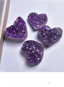 Detailed view of four heart-shaped Uruguayan natural amethyst clusters showing deep purple crystals