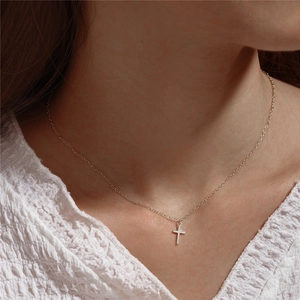 Close-up of minimalist S925 sterling silver cross pendant necklace worn on neck