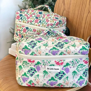 Close-up of quilted floral cosmetic bags with vintage flower patterns and top handles