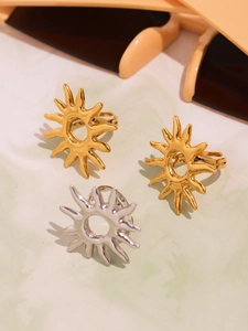 Detailed view of gold and silver sunburst rings with metallic finish in a summer setting