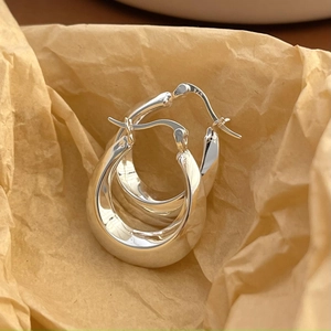 Minimalist S925 sterling silver U-shaped earrings on artistic paper background