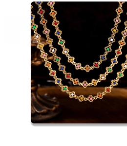 Detail of colorful gemstone necklace with golden clover frames on dark background