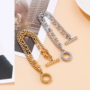 Detail of silver and gold stainless steel double chain bracelets with skull OT toggles