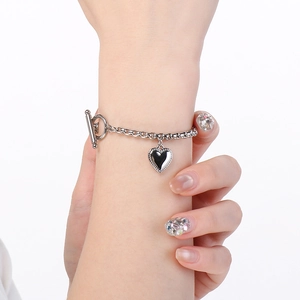 Vista dettagliata del bracciale con ciondolo a cuore argento e chiusura OT al polso