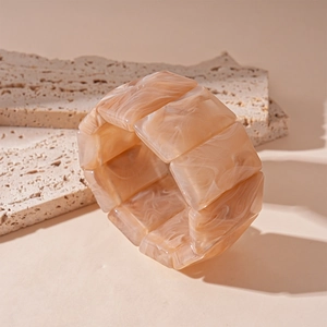Detailed macro view of acrylic resin bracelet with marble texture on travertine stone