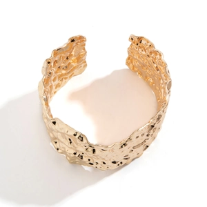 Punk style irregular textured golden open bracelet with a hammered metallic finish for women