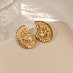 French vintage gold conch earrings with central pearl on a soft beige background