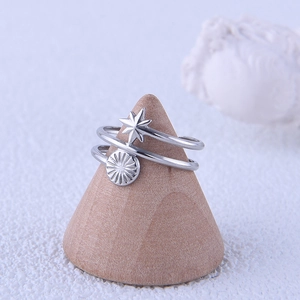 Silver stainless steel double layer open ring with sun and star motifs on a wooden stand