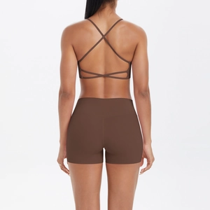 Detalle de sujetador de yoga con espalda cruzada y pantalones cortos de talle alto marrón