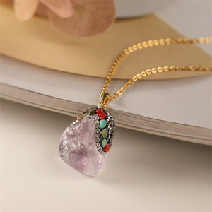 Macro detail of natural purple crystal pendant with colorful rhinestones on gold chain
