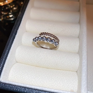 Detail of silver butterfly ring featuring grey pearls and elegant wheat ear design