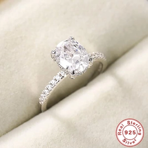 Macro detail of oval cut sterling silver ring with side pavé diamonds in jewelry box