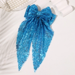 Detailed view of the sparkling blue sequins and flowing ribbons on the oversized hair bow