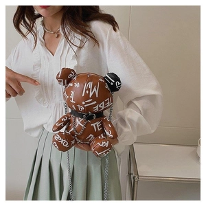 Detail of bear shaped crossbody bag with street style graffiti and silver chain strap