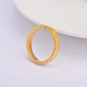 Macro detail of 18k gold plated ring with grooved vertical texture and polished finish