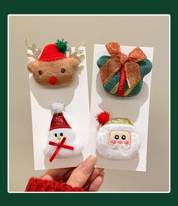 Detail showing set of four plush Christmas hair clips with reindeer and snowman figures