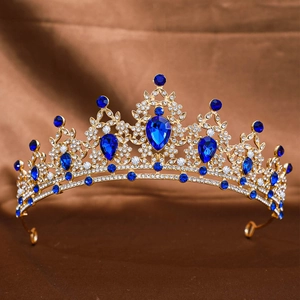 Close-up of golden bridal crown with blue gemstones and sparkling crystals for wedding