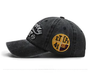 Detailed side view of washed black baseball cap with vintage embroidery and yellow patches