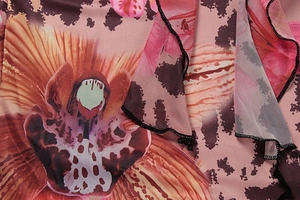 Detail of pink floral mesh fabric with ruffle edges and black fine stitching detail