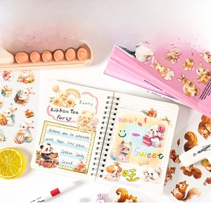 Flat lay of cute cartoon animal stickers and a grid notebook for DIY journaling