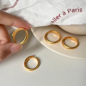 Minimalist matte gold open ring with S999 engraving on a white background scene