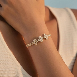 Close-up of bohemian 18K gold plated bracelet with clover shapes and baguette crystals