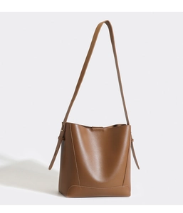 Minimalist brown leather bucket bag with shoulder strap and smooth texture